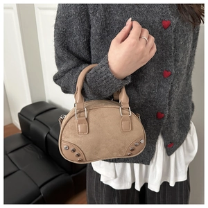 Detail of khaki suede bowling bag with silver studs and elegant shoulder strap