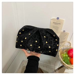Detail of black leopard print pleated clutch bag with golden rivets and soft suede texture