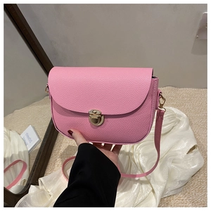 Detail of pink lychee leather crossbody saddle bag with gold metal buckle closure