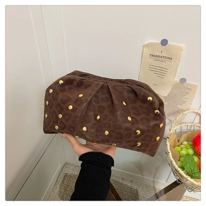 Detail of leopard print suede clutch with gold studs and soft pleated cloud design