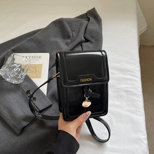 Modische schwarze Mini-Umhängetasche in Lackoptik mit goldenem Schriftzug und Metallanhänger
