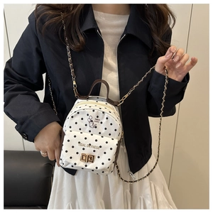 Détail d'un mini sac à dos à pois avec motif chat mignon et bandoulière dorée