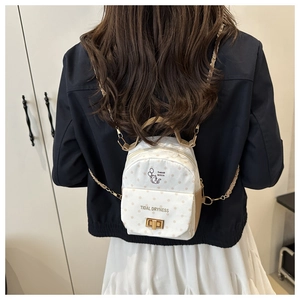 Détail du mini sac à dos à pois avec illustration de chat et bandoulière en chaîne dorée