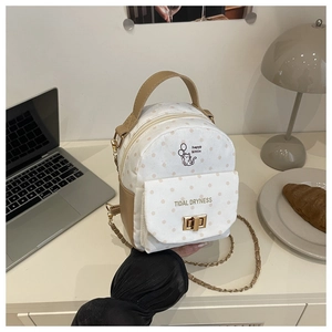 Détail du sac en toile à pois avec imprimé chat, fermoir rotatif et bandoulière dorée