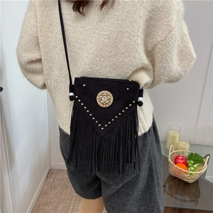 Boho black tassel saddle bag with golden studs and fringe detail shown in cross-body style