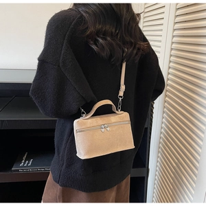 Détail du sac boîte minimaliste avec fermetures éclair coeur et texture daim