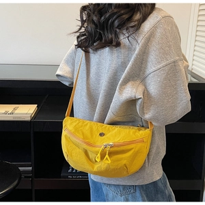 Détail d'un sac demi-lune en nylon jaune vif avec double zip et grand rangement