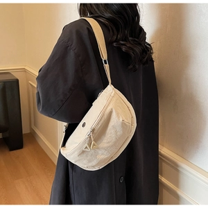 Détail du sac croissant en nylon crème avec doubles fermetures éclair triangulaires