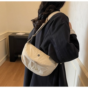 Détail du sac dumpling en nylon avec fermetures éclair et bandoulière réglable en tissu