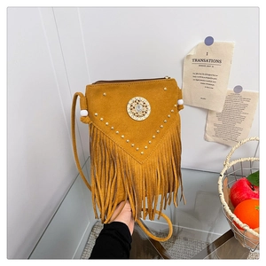 Detail of bohemian suede crossbody bag with fringe, golden rivets and vintage stone buckle