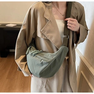 Detail of olive green nylon crescent bag with textured folds and matching wide strap