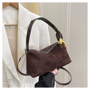 Détail du sac à main marron foncé avec ferrures dorées et empiècements en cuir suédé texturé