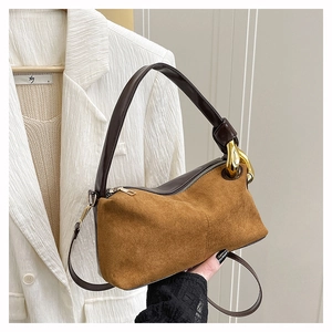 Détail du sac à main en daim marron avec de gros maillons de chaîne en métal doré élégant