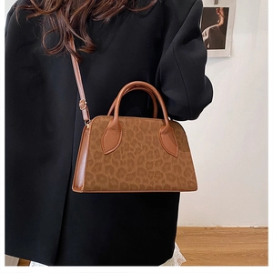 Detail of leopard print tote bag showing the matte texture and dark brown handle grip