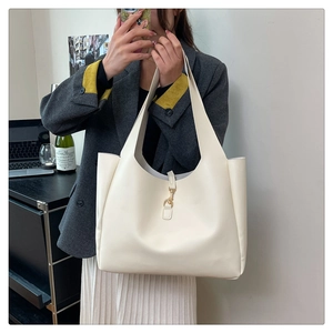Minimalist white leather tote bag featuring a refined gold metal hook clasp detail