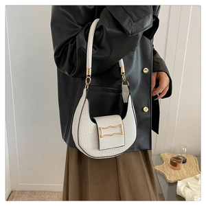 Detailed view of white half-moon underarm bag with crocodile texture and gold hardware
