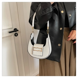 Detailed close-up of a white crocodile embossed crescent hobo bag with gold metal buckle
