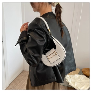 Detail of white crocodile pattern half-moon shoulder bag with golden metal buckle