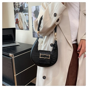 Detail of black crocodile texture crescent bag with vintage gold metal buckle
