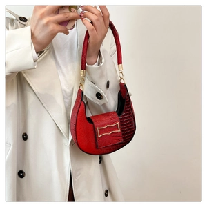 Close-up of red crocodile texture croissant shoulder bag on beige trench coat
