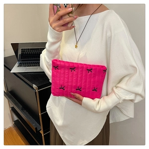 Détail de la pochette matelassée en velours fuchsia avec broderie de papillon
