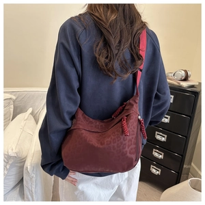 Detailed back view of a burgundy leopard print tote bag shown on a model
