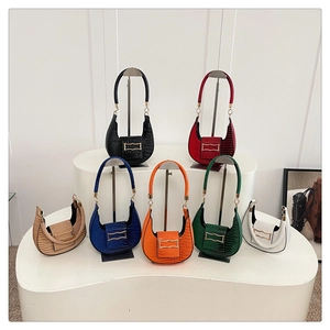 Collection of seven colorful crocodile embossed crescent bags on display stands