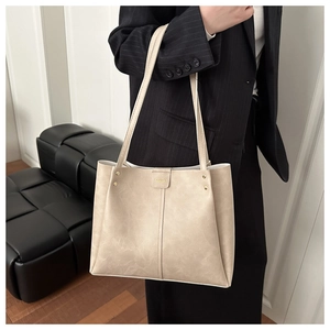 Detail of cream tote bag with marble texture, gold studs and Fashion logo on leather