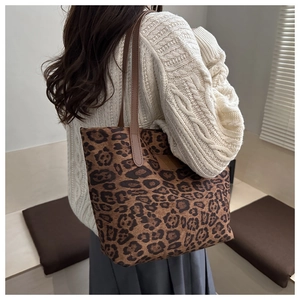 Detailansicht der Tragetasche mit Leopardenmuster und braunen Riemen am Model