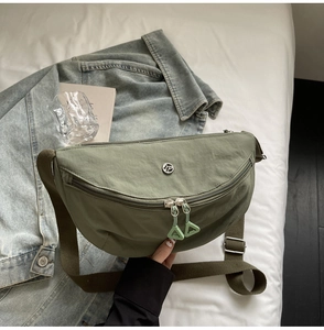 Sac banane croissant en nylon vert armée avec double fermeture éclair sur un drap blanc