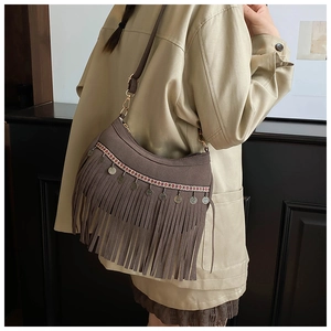 Nahaufnahme der braunen Wildledertasche mit Fransen und Ethno-Stickerei
