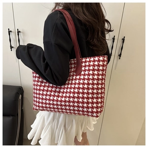 Detailed view of red houndstooth large tote bag on model for commuter fashion