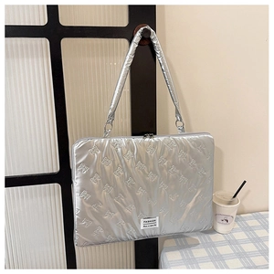 Silver quilted laptop bag detail with bow patterns and woven fashion label