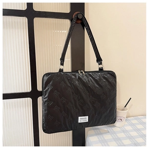 Close-up of black quilted nylon laptop bag with bow pattern and fashion logo tag
