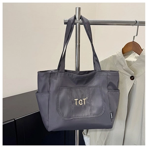 Détail du sac cabas gris foncé avec broderie TGT dorée et poches latérales pratiques