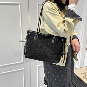 Chic black plush tote bag with leather handles shown on shoulder for daily commute
