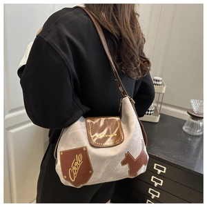 Detail der Vintage-Canvas-Tasche mit braunem Lederbesatz und dekorativem Patch