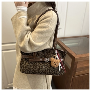 Detail of vintage leopard print tote bag with plush bear charm and adjustable leather strap