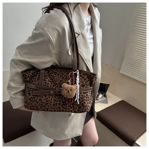 Detail of leopard print faux suede tote with leather straps and plush bear charm