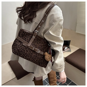 Detailed view of leopard print tote bag with adjustable strap and cute bear charm