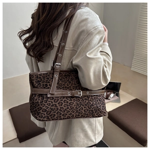 Detailed shoulder view of a vintage leopard print tote bag with brown leather straps
