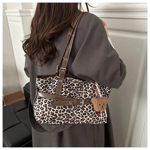 Suede leopard print tote bag side view with leather straps and bear charm detail