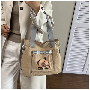 Detail of khaki panda print tote bag featuring dual zip pockets and MKPBL ribbon strap