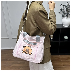 Detail of pink nylon tote bag featuring cute cartoon capybara print and grey straps