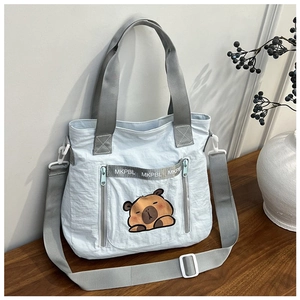 Close-up of light blue nylon tote bag with cute cartoon panda and adjustable strap