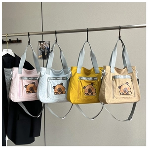 Multiple colorful nylon tote bags with cute cartoon capybara prints and shoulder straps