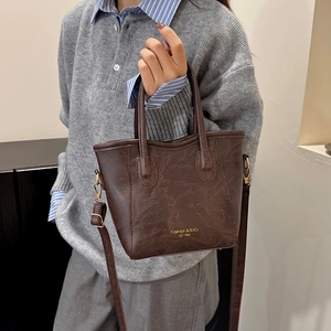Brown vintage marble texture bucket bag with top handle and crossbody strap on model
