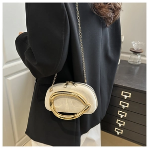 Chic cream faux suede crossbody bag with gold sculptural ring detail worn by model