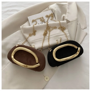 Detail of suede mini evening bags with oval gold metal handles and delicate chain straps