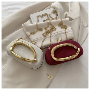 Detail showing elegant suede-like round mini clutch bags with gold metal handles and chains